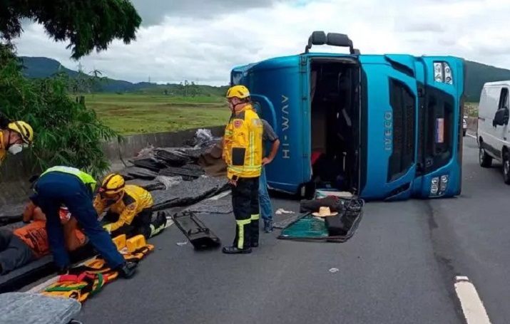 Carreta transportando madeira tomba e carga atinge ciclista na BR-470