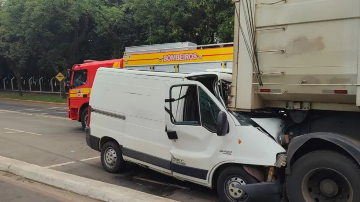 Van colide com carreta e motorista de 70 anos fica preso às ferragens