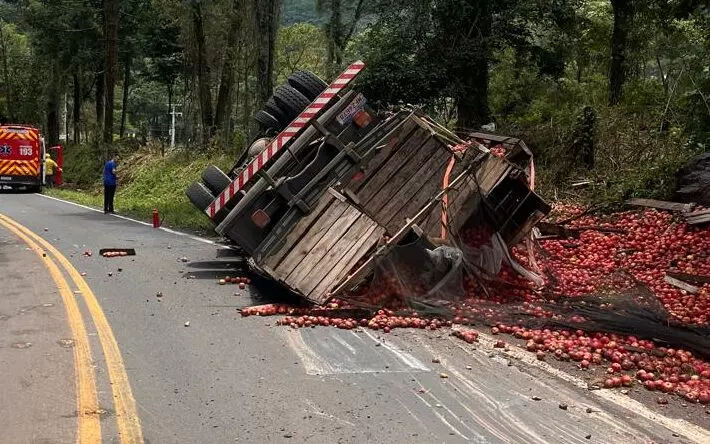 Caminhão de maçãs sai da pista e capota na SC-464; motorista fica ferido